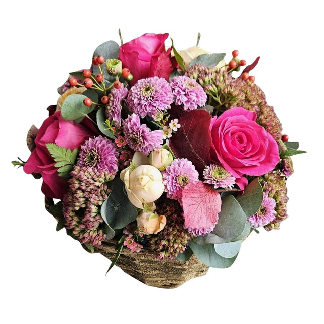 Herbstlicher Blumenkorb mit pinken Rosen, Chrysanthemen und Hagebutte