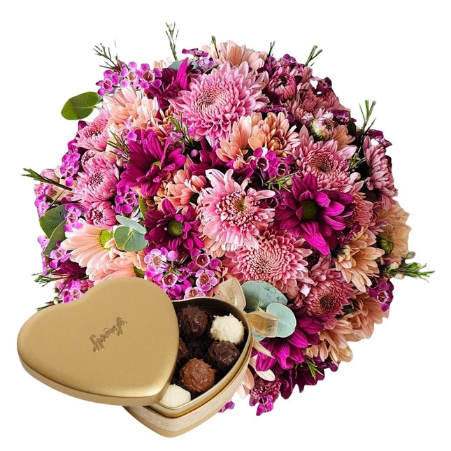 Blumenkorb mit lachsfarbenen und pinken Chrysanthemen mit sprüngli schokolade