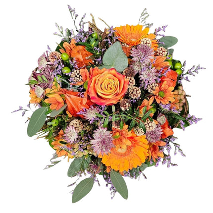 Herbstlicher Blumenkorb mit orangefarbenen Gerbera, Rosen, Beeren und lila Blumen