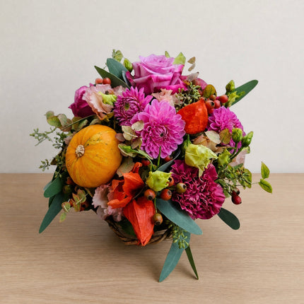 Buntes Herbstkörbli mit Zierkürbis und saisonalen Blumen