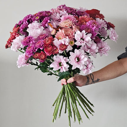 Üppiger Blumenstrauss aus rosa, pinken und violetten Chrysanthemen mit herbstlichem Laub von Blumen Krämer Zürich